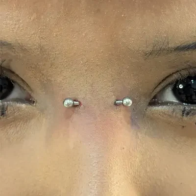 Bridge Piercing Close up of a woman's face showing a bridge piercing.